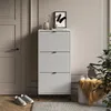 A hallway or entryway with a shoe cabinet, door, and a chair with a blanket. Produktbild-Vorschau