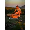 A woman is setting up a sleeping bag in a mountainous area at sunset. Anteprima dell’immagine prodotto