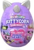 A purple egg-shaped toy with cat ears and a unicorn horn, featuring colorful branding and illustrations of characters. Produktbild-Vorschau