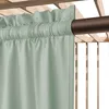 A close-up view of a sage green outdoor curtain hanging from a dark brown rod, attached to a wooden pergola structure. Podgląd zdjęcia produktu