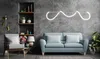 A modern living room with a blue sofa, armchair, shelves, and a unique pendant light. Produktbild-Vorschau
