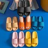 Person hält schwarze Slides, mit Paaren in Orange, Blau, Hellbraun, Pink und Gelb auf blauer Oberfläche angeordnet Náhľad obrázku produktu