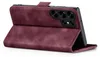 A close-up, angled view of a burgundy flip-style phone case, open to reveal the camera array of a smartphone inside. Produktbild-Vorschau