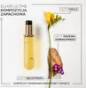 A bottle of hair oil with accompanying floral and wood elements, illustrating its scent composition. Voir les images du produit