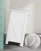 A white bathroom cabinet is shown leaning against a wall with a close-up inset showing a detail of the cabinet door handle. Voir les images du produit