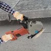 A person wearing gloves and a plaid shirt is using a wall chaser to cut into a concrete surface. Sparks are flying from the cutting blade. Náhled obrázku produktu