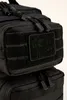 A close-up view of a black backpack, showing its texture and a patch with a logo. Náhled obrázku produktu