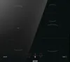 A black induction cooktop with illuminated heating zones. Voir les images du produit