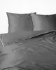 A close-up view of a gray duvet cover and two pillows with white piping. Náhled obrázku produktu