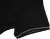 A close-up view of the sleeve and cuff of a black polo shirt. Produktbild-Vorschau