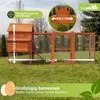 A wooden chicken coop with an attached run, set up on a grassy lawn. Produktbild-Vorschau