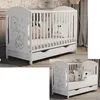Two views of a white baby crib with teddy bear illustrations and a drawer.