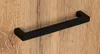A black handle is shown against a wooden background. Podgląd zdjęcia produktu