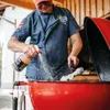 A person is cleaning a grill. Produktbild-Vorschau