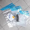 A collection of vacuum seal bags and a box of storage bags laid out on a tiled floor. Podgląd zdjęcia produktu