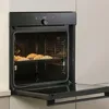 An open built-in oven with a baking tray of croissants inside. Anteprima dell’immagine prodotto