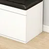 A close-up view of the corner of a white storage bench with a black cushioned top, placed on a wooden floor next to a wall with white baseboards. Anteprima dell’immagine prodotto