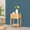 A wooden nightstand with a drawer and a shelf, decorated with a vase of flowers and a teacup. Podgląd zdjęcia produktu