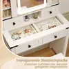 A close-up view of a white vanity table with drawers and a transparent glass top, showcasing various cosmetics and jewelry. Voir les images du produit