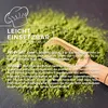 A pile of green moringa powder with a wooden scoop, with text overlays. Produktbild-Vorschau