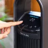A close-up shot of a person's finger pressing a button on the control panel of a black appliance, likely a fan or heater. Anteprima dell’immagine prodotto