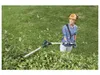 A woman is using a telescopic hedge trimmer to trim bushes in a garden. Produktbild-Vorschau