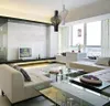 A modern living room with a sectional sofa, glass coffee tables, and a large window with curtains. Produktbild-Vorschau