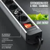 A close-up of a silver and black power strip with multiple outlets and a red illuminated switch, set against a dark gray background. Green leaves are visible in the upper right corner. Voir les images du produit