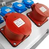 A close-up view of several industrial electrical outlets, some red and some blue, mounted on a white panel. Náhled obrázku produktu