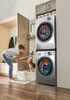 A woman and her dog in a laundry room with a stacked washer and dryer. Podgląd zdjęcia produktu