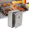 A close-up view of a stainless steel rotisserie motor attachment for a grill, with a grill and food in the background. Náhled obrázku produktu
