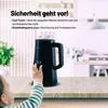 A baby's hand reaches towards a black electric kettle with a digital display showing 95°C, set on a wooden table in a kitchen environment. Anteprima dell’immagine prodotto