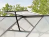 A close-up view of an open automatic vent on a greenhouse roof, with trees visible in the background. Produktbild-Vorschau