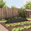 A garden scene with a protective tunnel over young plants, a wooden fence, and gardening tools in the background. Náhľad obrázku produktu