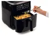 A hand is pouring oil onto french fries in an air fryer. Náhľad obrázku produktu