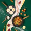 A top-down view of cooking ingredients and cookware on a green surface. Náhľad obrázku produktu