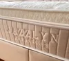 Close-up of the side of a mattress with brand name and bedding details embossed. Produktbild-Vorschau