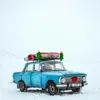 A blue car decorated for Christmas, parked in a snowy landscape. Podgląd zdjęcia produktu
