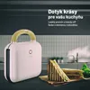 A pink sandwich maker with a wooden handle sits on a dark surface next to a sandwich and lettuce. Náhľad obrázku produktu