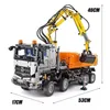 A detailed view of a remote-controlled construction toy truck with a crane and dump bed, with dimensions indicated. Voir les images du produit