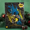 A Batman advent calendar is displayed in front of a green background, surrounded by festive greenery and ornaments. Anteprima dell’immagine prodotto