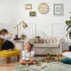 Two young children playing on the floor in a living room with a sofa and toys. Produktbild-Vorschau