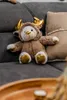 A plush toy reindeer bear sits on a sofa. Náhľad obrázku produktu