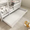 A white bunk bed with a pull-out drawer is shown in a bedroom setting. Produktbild-Vorschau