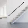 A modern interior with a floating staircase and a black metal handrail mounted on a white wall. Náhled obrázku produktu