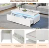 A modern white coffee table with LED lighting and storage drawers, shown in a living room setting and with close-up detail shots. Voir les images du produit