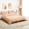 A bedroom scene with a bed dressed in pink bedding with text. Voir les images du produit