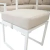 A close-up of a beige cushion on a white metal frame stool, with a blurred background of a white outdoor sofa set. Produktbild-Vorschau