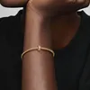 A close-up shot of a person's arm wearing a gold Pandora bracelet with a clip charm. Produktbild-Vorschau