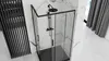 A modern black shower cabin with glass doors and black fixtures, set against a marble-tiled wall and white tiled floor. Produktbild-Vorschau